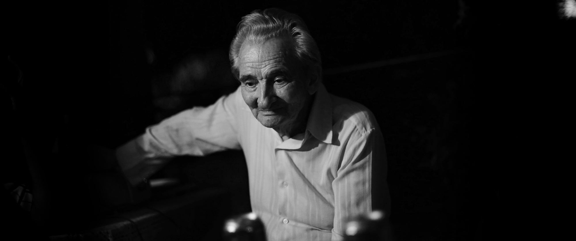 Black and white photograph of Licu, a 92-year-old man staring into space. He is sitting on a chair.